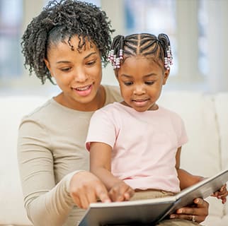 Person reading a toddler a book about toilet training.